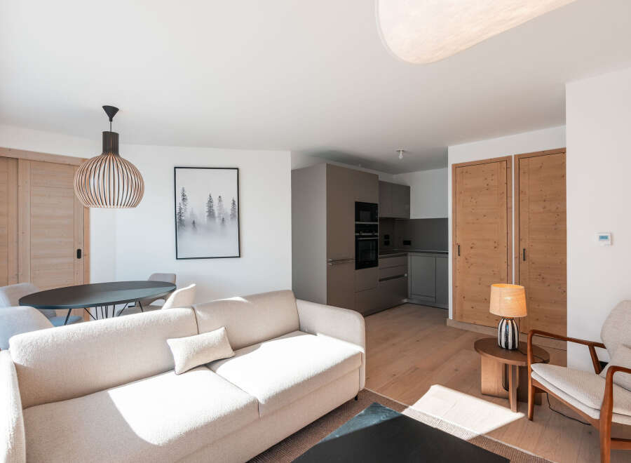 This stunning apartment boasts a spacious open-plan living area with a comfortable sofa and modern kitchen.