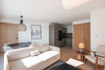 This stunning apartment boasts a spacious open-plan living area with a comfortable sofa and modern kitchen.