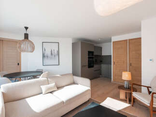This stunning apartment boasts a spacious open-plan living area with a comfortable sofa and modern kitchen.