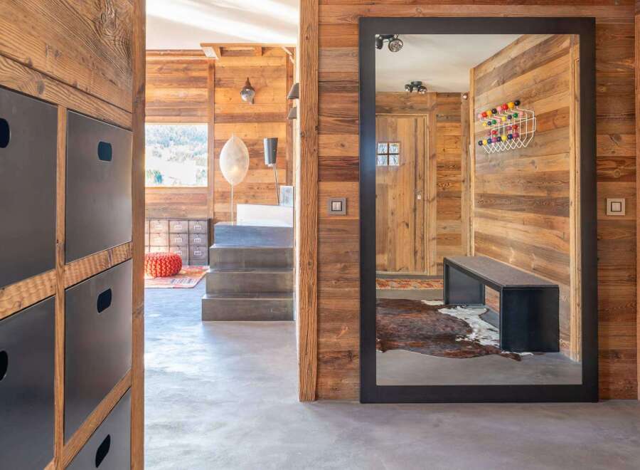 This stunning chalet boasts a spacious entryway with rustic wood walls and modern metal accents.
