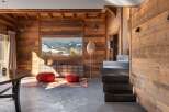 This stunning chalet boasts a rustic-chic interior with exposed wooden beams and walls, creating a warm and inviting atmosphere.