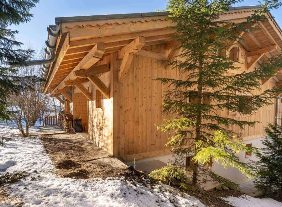 This stunning chalet boasts a beautiful wooden exterior, perfect for a cozy mountain getaway.