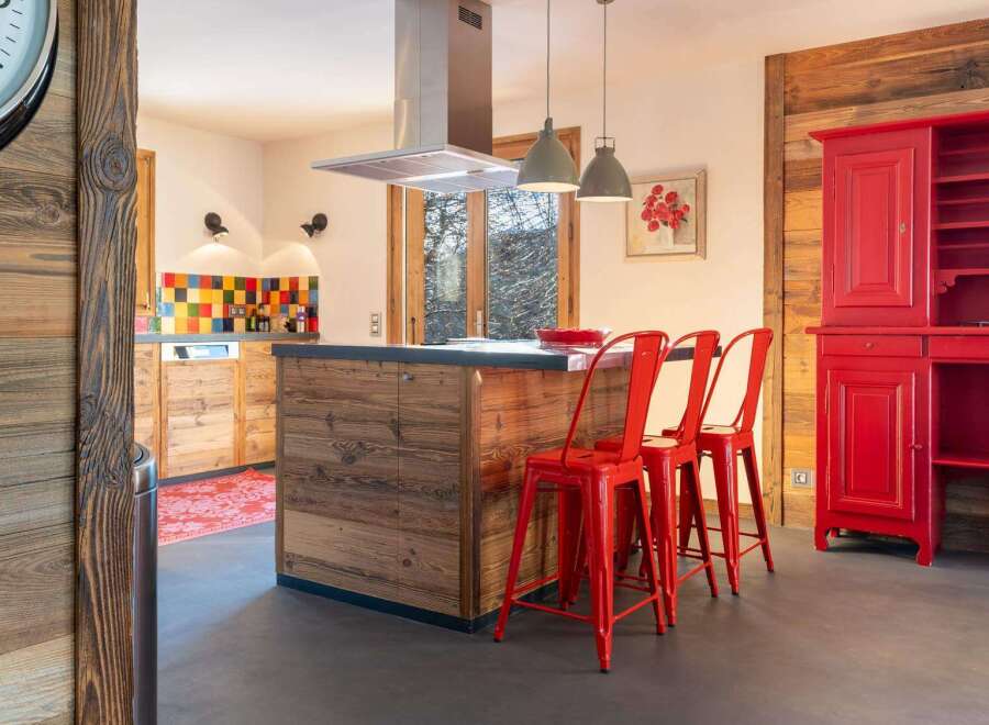Rustic mountain kitchen with reclaimed wood finishes and red accents.