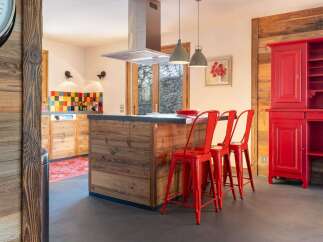 Rustic mountain kitchen with reclaimed wood finishes and red accents.