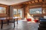 This stunning chalet boasts a spacious open-plan living area with floor-to-ceiling windows offering breathtaking mountain views.