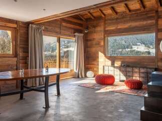 This stunning chalet boasts a spacious open-plan living area with floor-to-ceiling windows offering breathtaking mountain views.