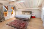 This stunning bedroom boasts a cozy atmosphere with its rustic wooden beams and large windows offering breathtaking views.