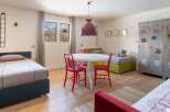 Stylish kids' bedroom with twin beds, a playful metal locker, and a bright, airy atmosphere.