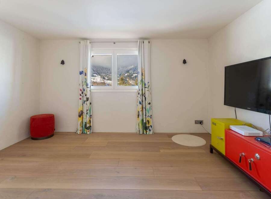 Bright and airy room with hardwood floors, featuring a large window showcasing scenic mountain views.
