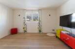 Bright and airy room with hardwood floors, featuring a large window showcasing scenic mountain views.