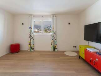 Bright and airy room with hardwood floors, featuring a large window showcasing scenic mountain views.