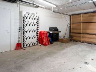 This spacious garage boasts ample storage solutions, including a dedicated boot dryer and ample space for seasonal items.