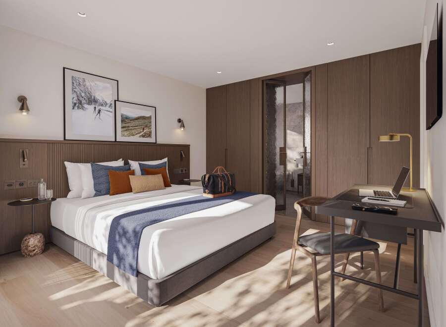 This stunning hotel room boasts a king-size bed with plush bedding, a spacious work desk with a laptop, and large windows that let in plenty of natural light.