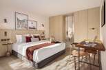 This stunning hotel room boasts a king-size bed with plush bedding, a spacious work desk with a laptop, and ample closet space.