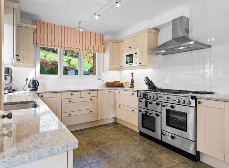 This stunning kitchen boasts a spacious layout with ample counter space and sleek cabinetry.