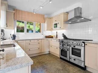 This stunning kitchen boasts a spacious layout with ample counter space and sleek cabinetry.