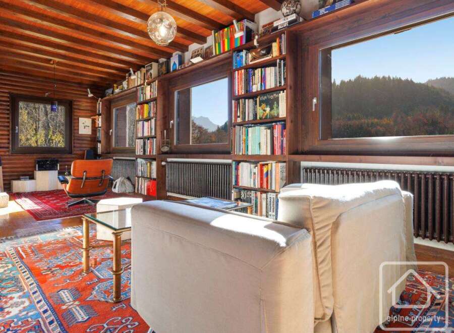This stunning property boasts a spacious living area with floor-to-ceiling windows offering breathtaking views of the surrounding mountains.