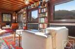 This stunning property boasts a spacious living area with floor-to-ceiling windows offering breathtaking views of the surrounding mountains.