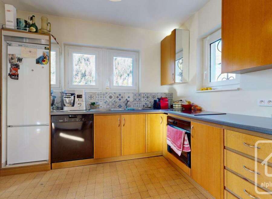 This charming kitchen boasts light wood cabinets, a tiled backsplash, and ample counter space.