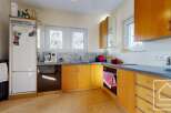 This charming kitchen boasts light wood cabinets, a tiled backsplash, and ample counter space.