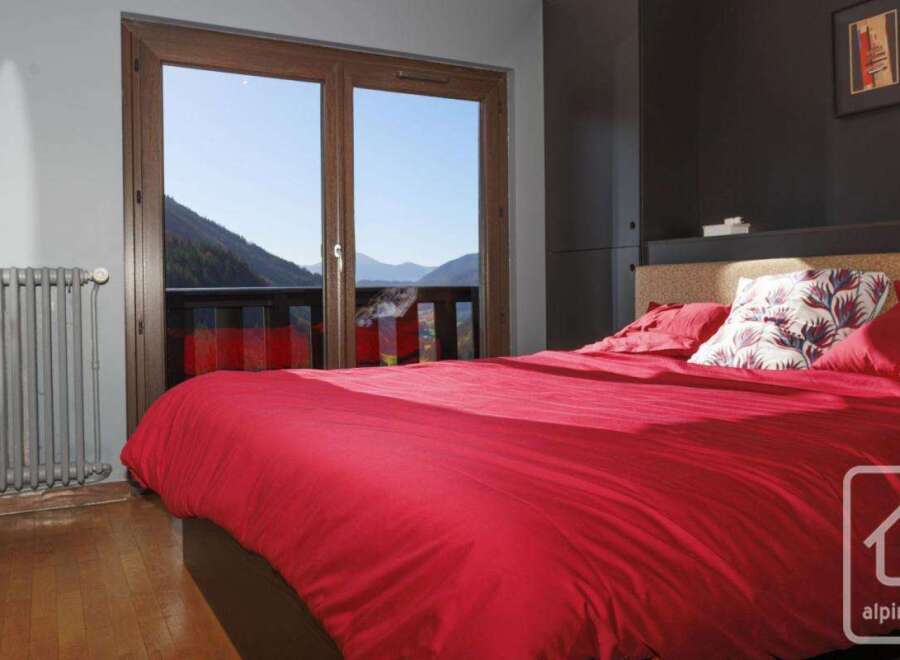Wake up to breathtaking mountain views from this cozy bedroom, featuring a comfortable double bed and stylish decor.