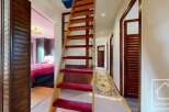 This charming property boasts a unique wooden staircase with red carpeting, adding a touch of elegance to the hallway.