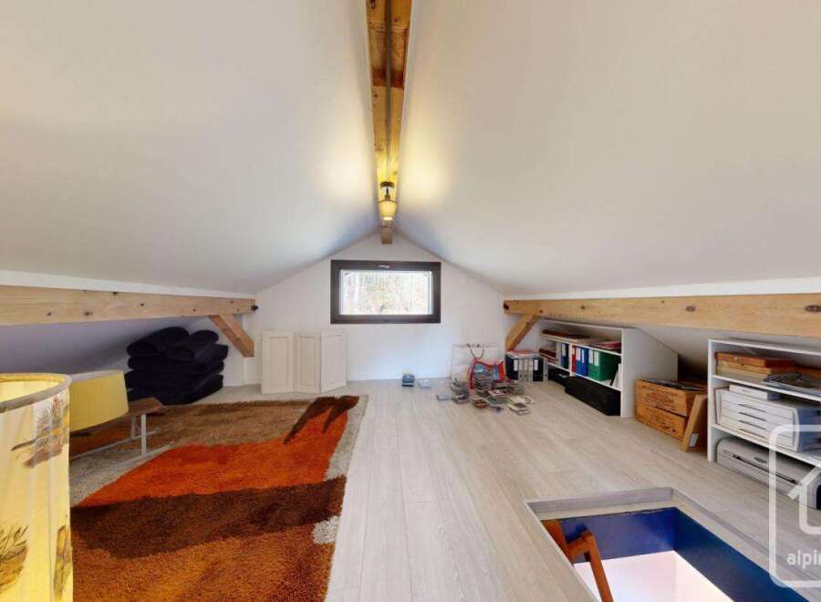 This attic room boasts ample storage solutions, including built-in shelving units and cabinets, perfect for organizing belongings.