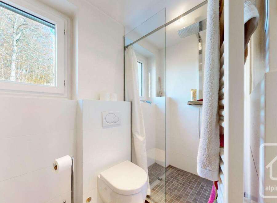 This modern bathroom boasts a walk-in shower with glass enclosure and a stylish toilet.