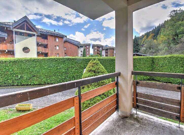 This charming apartment boasts a private balcony overlooking a lush green landscape and the surrounding mountain views.
