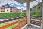 This charming apartment boasts a private balcony overlooking a lush green landscape and the surrounding mountain views.