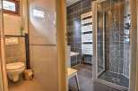 This charming property boasts a modern bathroom with a walk-in shower and a wall-mounted toilet.
