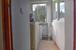 This property boasts a convenient laundry area with a washing machine, located in a sunlit space with a window offering scenic views.