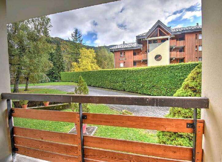 This stunning property boasts a beautiful balcony overlooking a lush green landscape and a charming residential building.