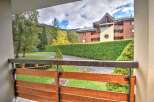 This stunning property boasts a beautiful balcony overlooking a lush green landscape and a charming residential building.