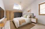 This stunning bedroom boasts a cozy and modern design, featuring a comfortable bed with a neutral color palette and stylish wooden accents.