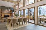 This stunning property boasts a spacious open-plan living area with floor-to-ceiling windows offering breathtaking views of a snowy landscape.