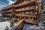 This stunning chalet boasts multiple levels of expansive wooden balconies, offering breathtaking views of the snowy landscape.