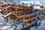 Nestled in a snowy mountainside, this luxurious chalet boasts stunning views and exquisite wooden architecture.