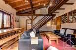 This charming chalet boasts a spacious open-plan living area with exposed wooden beams, creating a warm and inviting atmosphere.