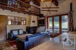 This charming chalet boasts a spacious living area with comfortable leather sofas, a cozy fireplace, and large windows offering stunning views of the surrounding landscape.
