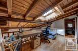 Discover this unique chalet featuring a charming attic workspace with exposed wooden beams and skylights, creating a bright and inspiring atmosphere.