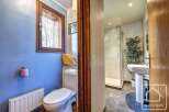 This charming bathroom boasts a modern toilet and sink, complemented by a walk-in shower.