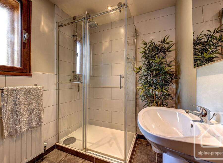 This stunning bathroom boasts a spacious walk-in shower with glass doors and modern fixtures.