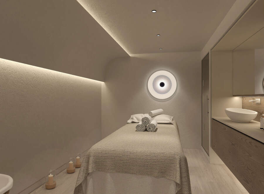 Relax in this serene spa room, featuring a comfortable massage bed with plush towels, ambient lighting, and calming decor.