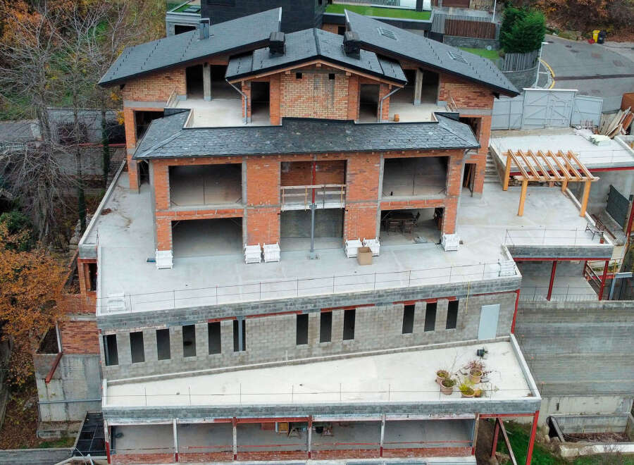 Luxury chalet under construction in the mountains, offering stunning views.