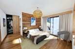 This stunning bedroom boasts a rustic wood accent wall and a cozy ambiance, perfect for relaxation.
