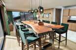 Experience luxury living in this stunning property, featuring a spacious dining area with a unique live-edge table and stylish seating.