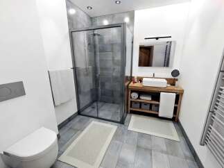 Step into a modern bathroom oasis! This stunning space features a sleek glass shower, a stylish wooden vanity, and elegant tile flooring.