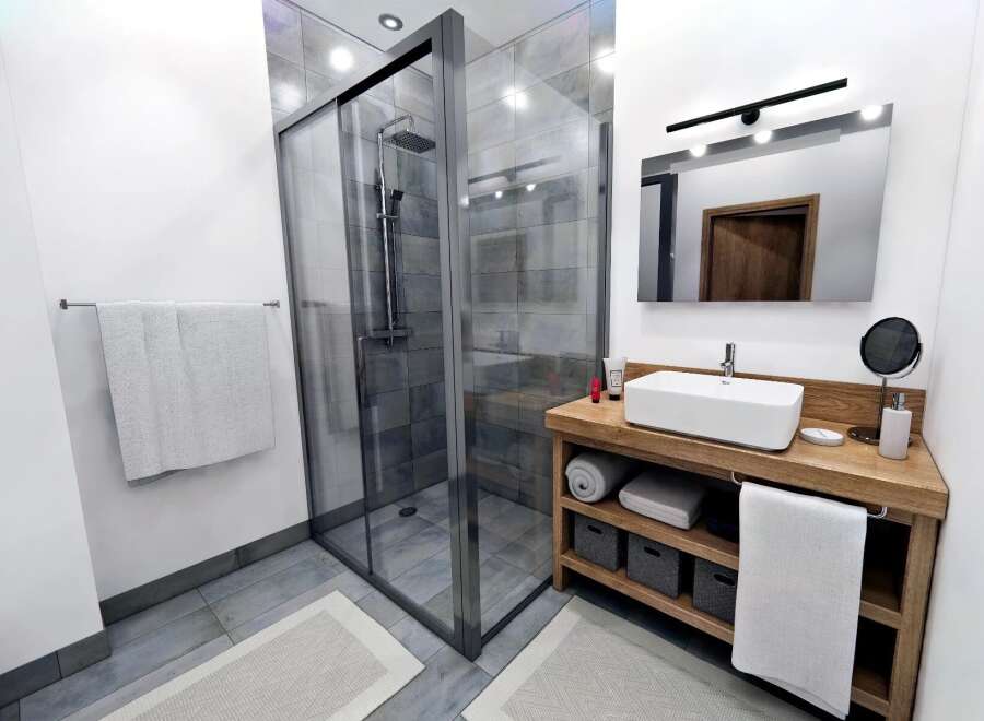 Step into a modern bathroom oasis! This stunning space features a sleek glass shower, a stylish wooden vanity, and elegant tile flooring.