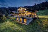 Nestled in a serene mountain landscape, this stunning property boasts a modern chalet design with expansive windows that offer breathtaking views.